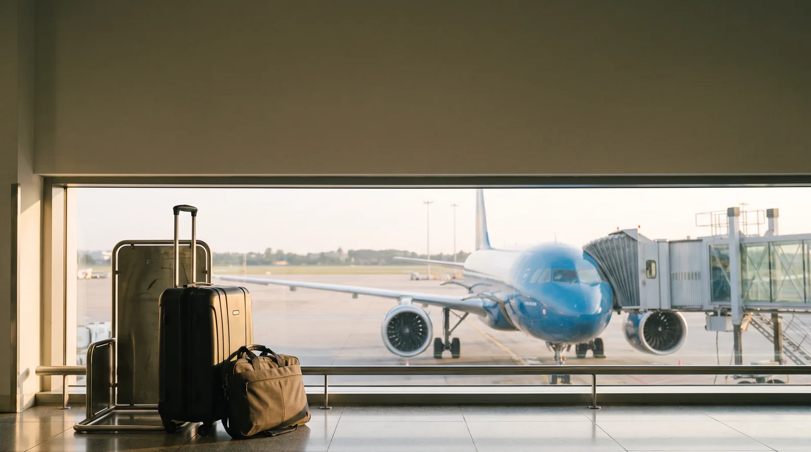 Trolley e borsa per il portatile accanto al misuratore, Airbus blu al gate