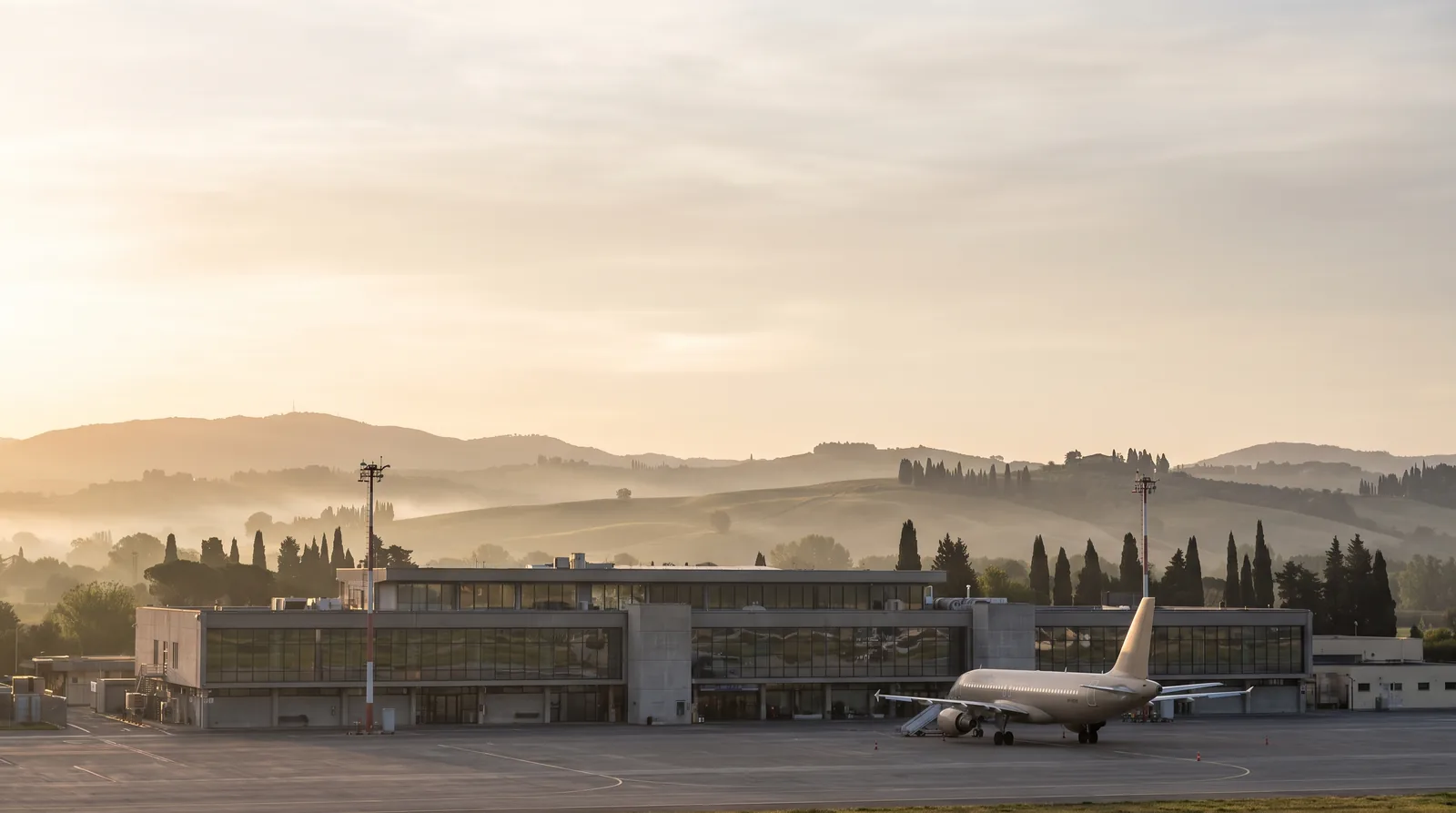 Aeroporto di Pisa Galileo Galilei - piazzale con aereo in sosta e colline toscane sullo sfondo